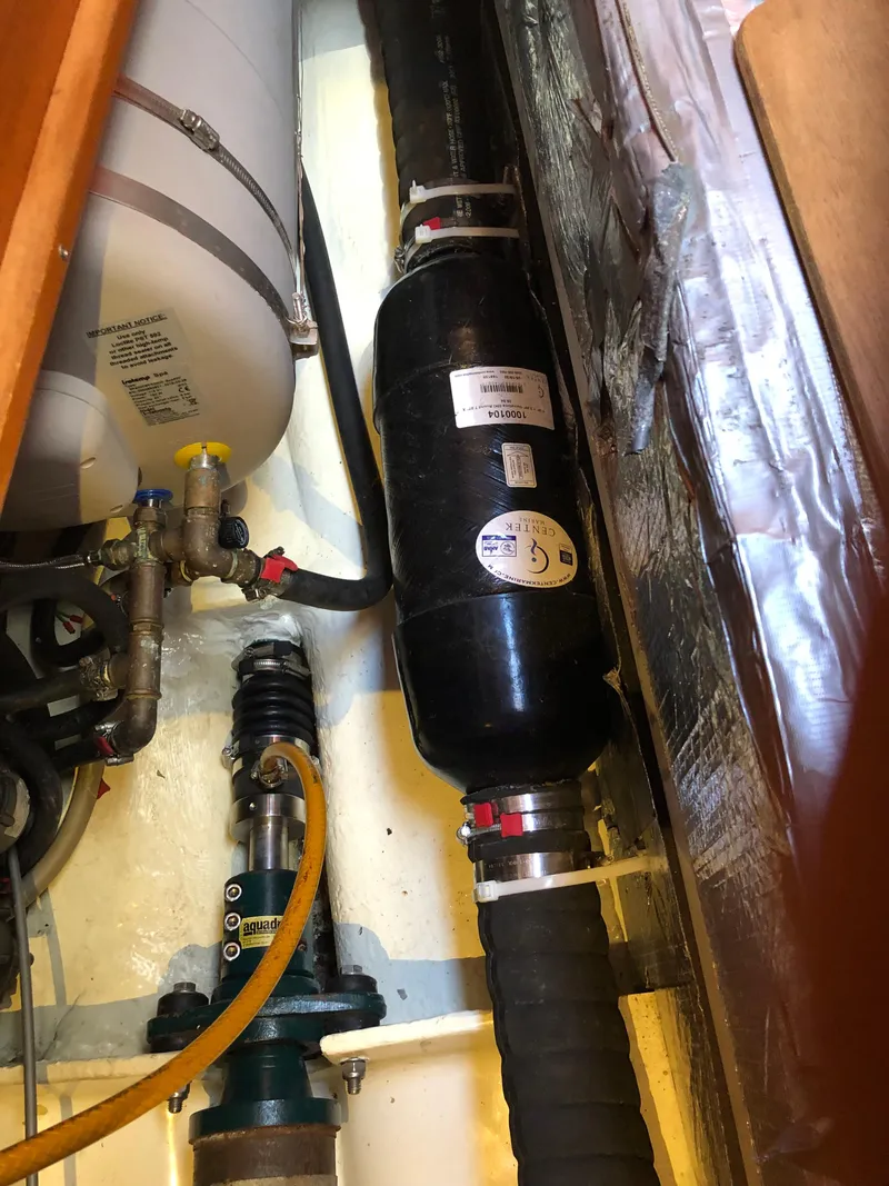 Slide: The Image of Engine compartment of a 2001 Malo 43 sailboat, showing pipes and mechanical components. - 54