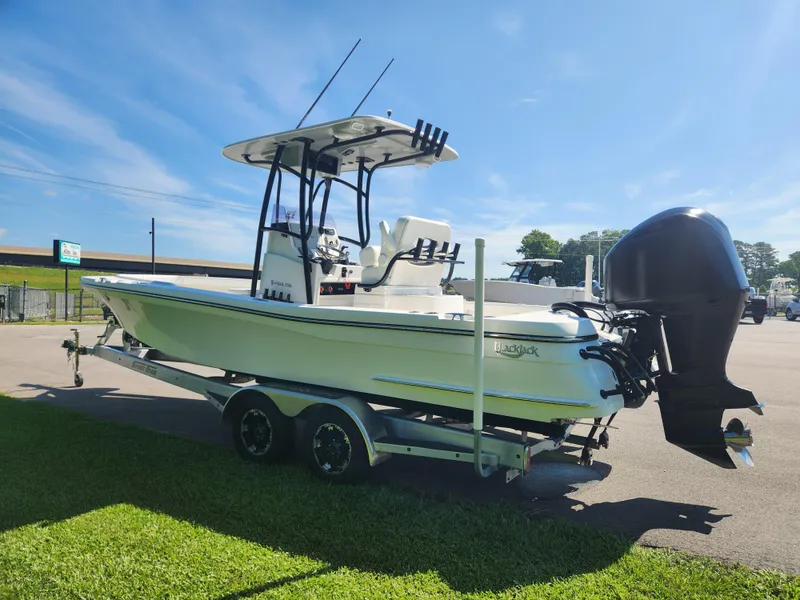 Slide: The Image of 2021 BlackJack 256 Coastal boat on trailer, parked outdoors under clear blue sky. - 5