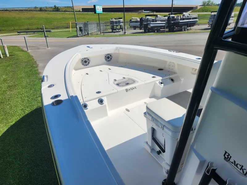 Slide: The Image of 2021 BlackJack 256 Coastal boat with spacious deck and seating, parked outdoors. - 8