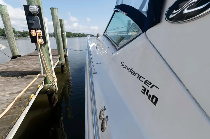 Slide: The Image of 2007 Sea Ray 340 Sundancer docked at a marina, showcasing sleek design and branding. - 11