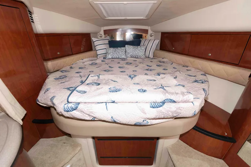 Slide: The Image of Luxurious cabin interior of 2007 Sea Ray 340 Sundancer with cozy bedding and wood accents. - 16