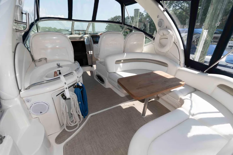 Slide: The Image of 2007 Sea Ray 340 Sundancer interior with white seating, wooden table, and cockpit view. - 3