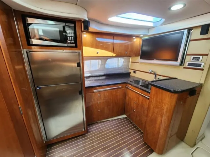 Slide: The Image of Luxurious 2008 Four Winns V458 yacht kitchen with wood cabinetry, stainless steel appliances, and modern amenities. - 13