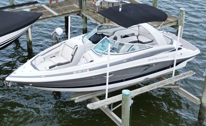 Slide: The Image of 2023 Crownline 270 SS boat docked on a lift, featuring sleek design and spacious seating. - 0