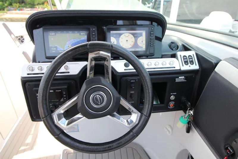 Slide: The Image of 2023 Crownline 270 SS boat dashboard with steering wheel and navigation displays. - 11