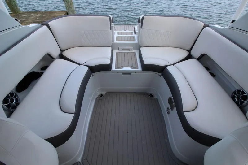 Slide: The Image of 2023 Crownline 270 SS boat interior with white cushioned seating and water view. - 14