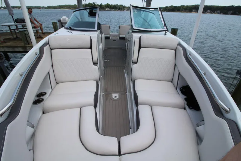Slide: The Image of 2023 Crownline 270 SS boat interior with white cushioned seating and lake view. - 18