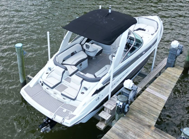 Slide: The Image of 2023 Crownline 270 SS boat docked, featuring sleek design and spacious seating. - 2