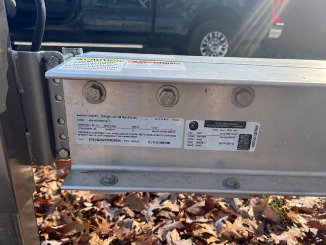 Slide: The Image of Trailer hitch with label, surrounded by autumn leaves, near a parked truck. - 24