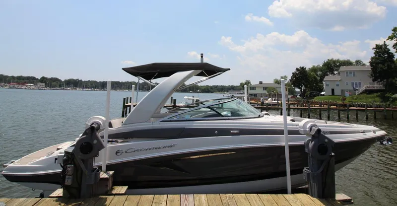 Slide: The Image of 2023 Crownline 270 SS boat docked by a scenic waterfront. - 3