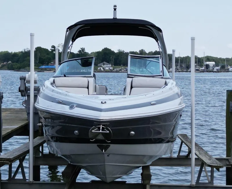 Slide: The Image of 2023 Crownline 270 SS boat docked on a serene lake with scenic background. - 6
