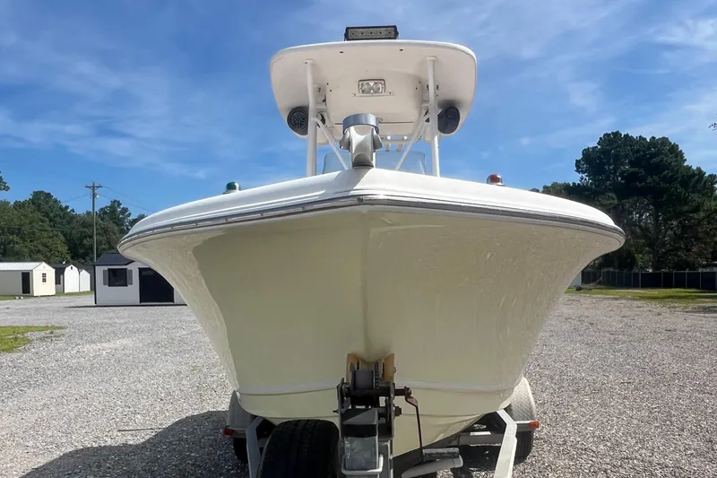 Slide: The Image of 2010 Tidewater 216 CC Adventure boat on trailer, parked outdoors under clear sky. - 2