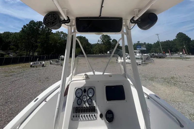 Slide: The Image of Tidewater 216 CC Adventure 2010 boat dashboard with gauges and controls, parked outdoors. - 7