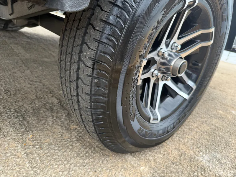 Slide: The Image of Close-up of a 2022 Skeeter ZX 150 tire and alloy wheel on concrete surface. - 10