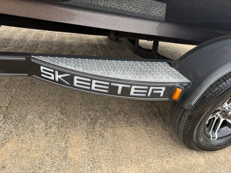 Slide: The Image of 2022 Skeeter ZX 150 trailer with diamond plate step and logo, parked on concrete. - 11