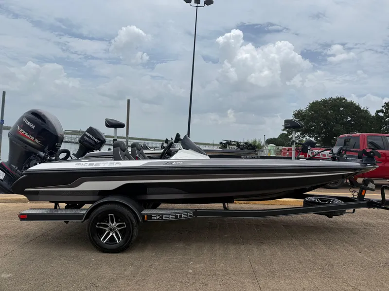 Slide: The Image of 2022 Skeeter ZX 150 boat on trailer, parked outdoors under cloudy sky. - 18