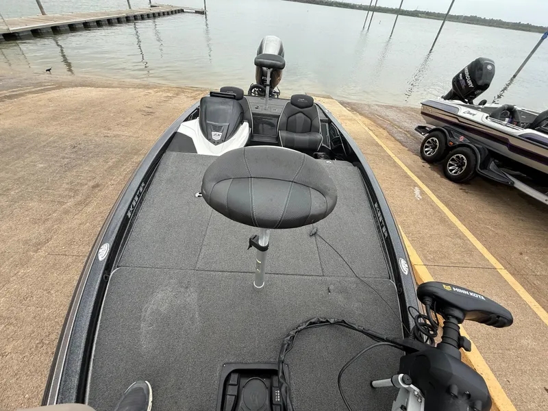 Slide: The Image of 2022 Skeeter ZX 150 boat at a lakeside dock, featuring a spacious deck and seating. - 28