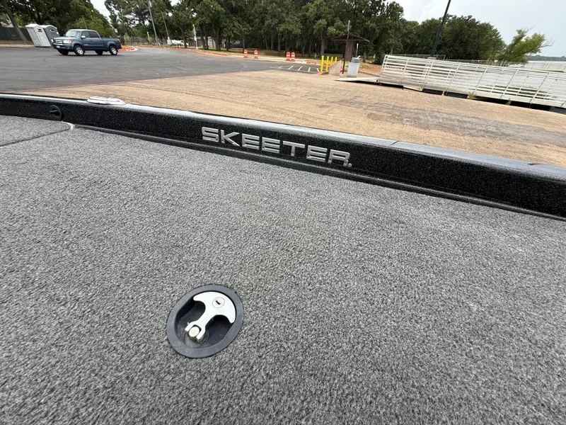 Slide: The Image of 2022 Skeeter ZX 150 boat deck with logo, parked near a lake. - 36