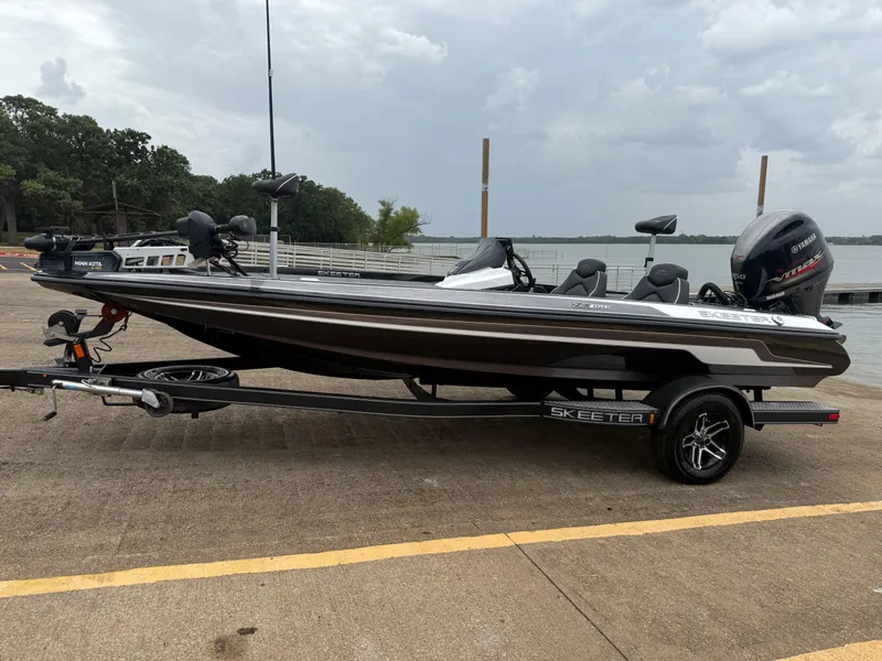 Slide: The Image of 2022 Skeeter ZX 150 boat on trailer by lake, overcast sky background. - 4