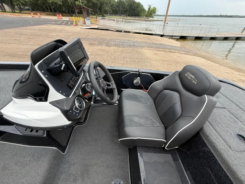 Slide: The Image of 2022 Skeeter ZX 150 boat interior with steering console and comfortable seating by the lake. - 40
