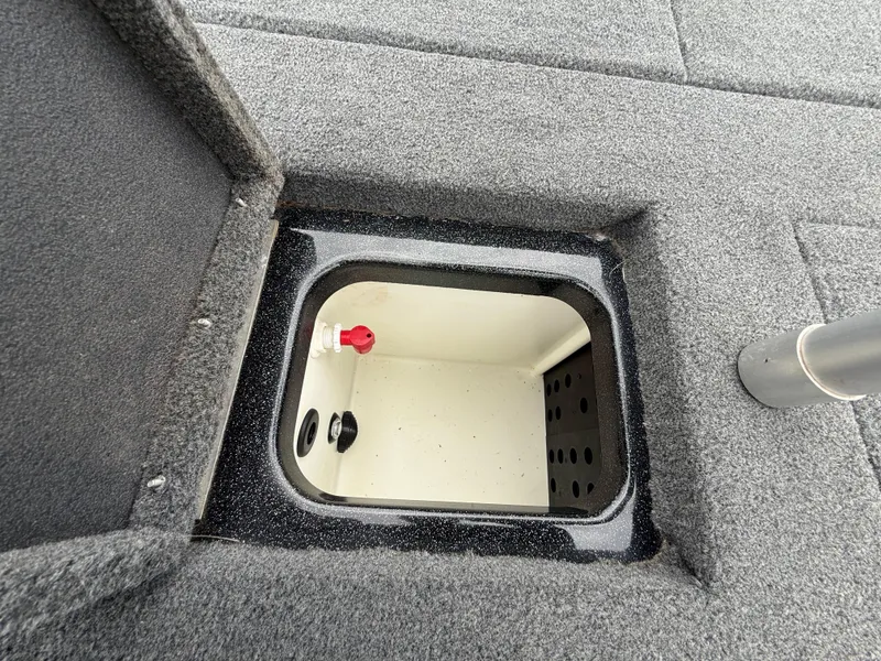 Slide: The Image of 2022 Skeeter ZX 150 boat storage compartment with open lid, featuring carpeted interior. - 44