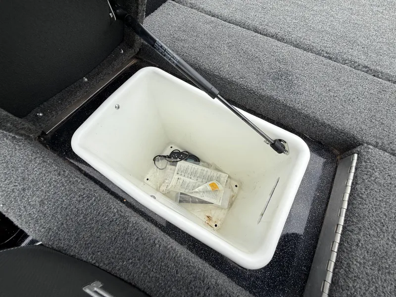 Slide: The Image of Storage compartment in 2022 Skeeter ZX 150 boat, featuring a white interior and hydraulic lift. - 47