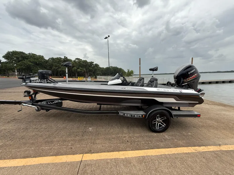 Slide: The Image of 2022 Skeeter ZX 150 boat on trailer by a lake under cloudy skies. - 5