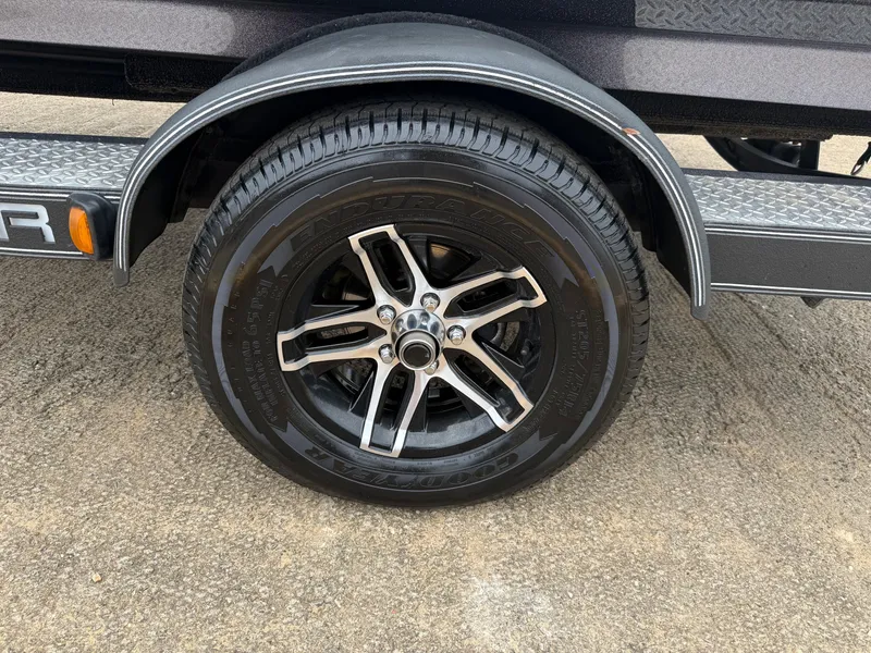 Slide: The Image of 2022 Skeeter ZX 150 trailer tire with black alloy wheel on concrete surface. - 9