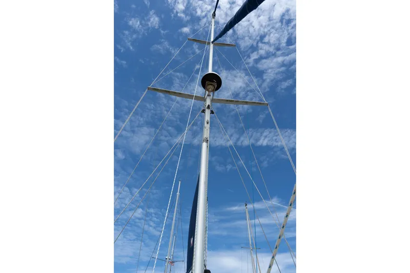 Slide: The Image of Mast of 2004 Island Packet 485 sailboat against a blue sky with clouds. - 14