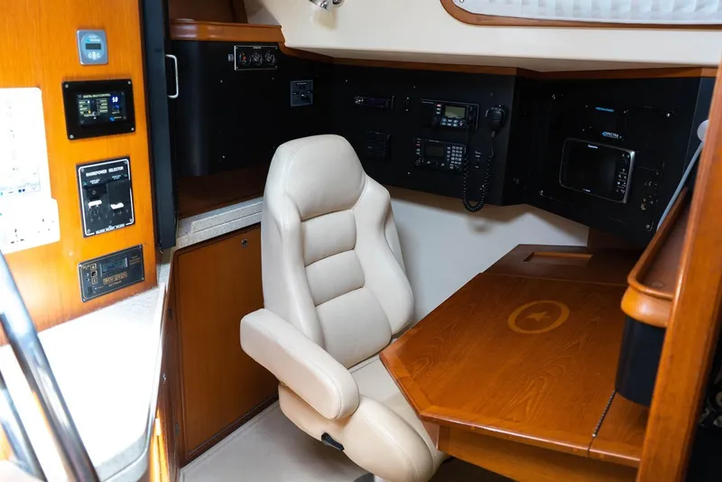 Slide: The Image of Navigation station of 2004 Island Packet 485 yacht with leather chair and control panels. - 19