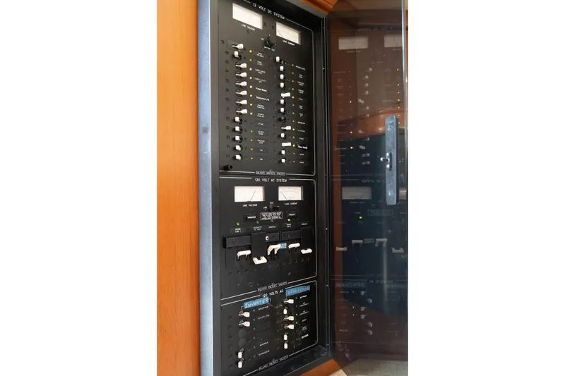 Slide: The Image of Electrical control panel on a 2004 Island Packet 485 yacht, featuring switches and meters. - 24