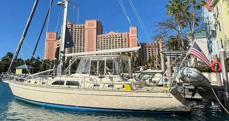 Slide: The Image of 2004 Island Packet 485 sailboat docked near luxury resort buildings. - 3