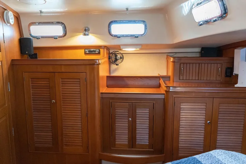 Slide: The Image of Interior of 2004 Island Packet 485 yacht with wooden cabinetry and portholes. - 36