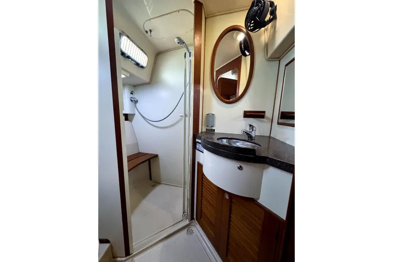 Slide: The Image of Luxurious 2004 Island Packet 485 yacht bathroom with shower, sink, and wooden accents. - 41