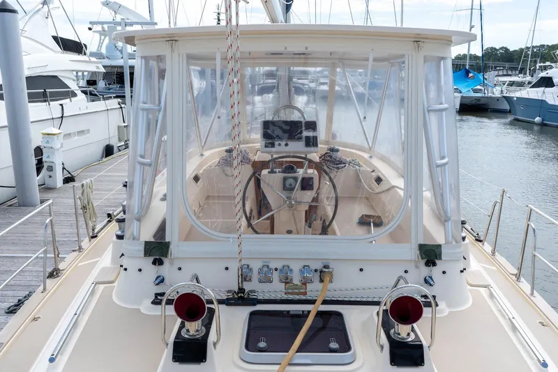 Slide: The Image of 2004 Island Packet 485 yacht cockpit view at marina, showcasing steering and navigation equipment. - 5