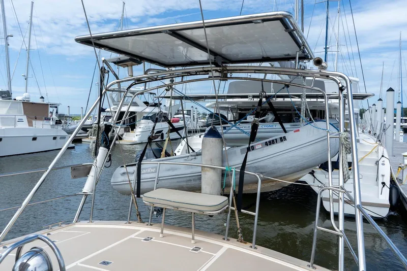 Slide: The Image of 2004 Island Packet 485 sailboat with dinghy at marina, surrounded by other boats. - 6