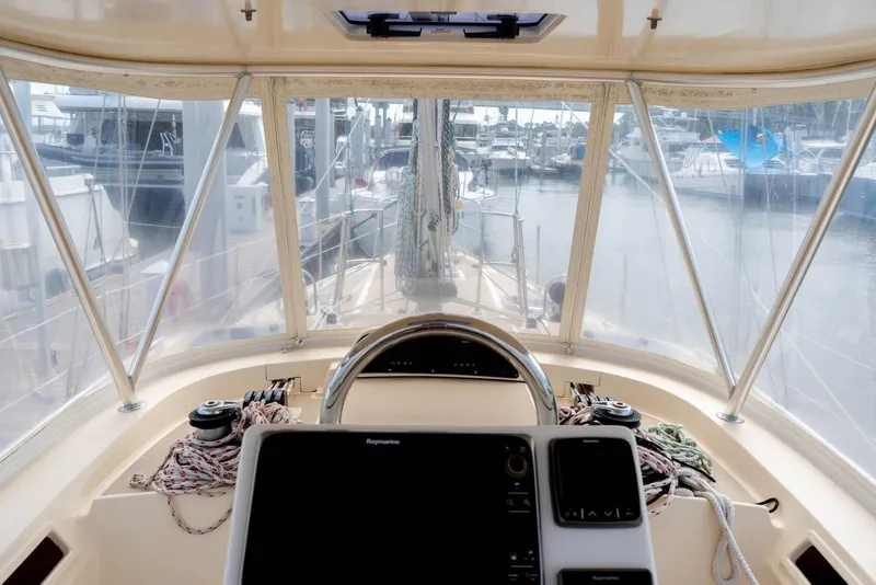 Slide: The Image of Cockpit view of 2004 Island Packet 485 sailboat, featuring navigation equipment and marina backdrop. - 7