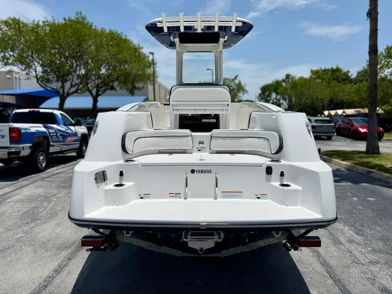 Slide: The Image of 2025 Yamaha Boats 255 FSH Sport H, rear view, parked outdoors on a sunny day. - 5