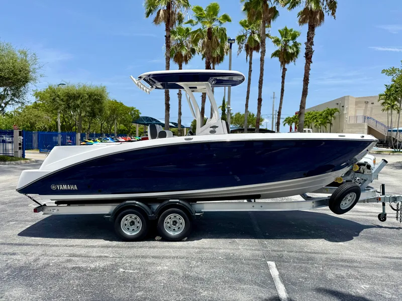 Slide: The Image of 2025 Yamaha Boats 255 FSH Sport H on trailer, parked outdoors with palm trees. - 6