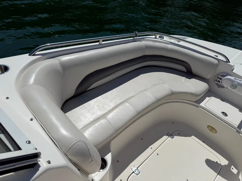 Slide: The Image of 2006 Hurricane SD 237 boat interior with cushioned seating and speaker, on calm water. - 11