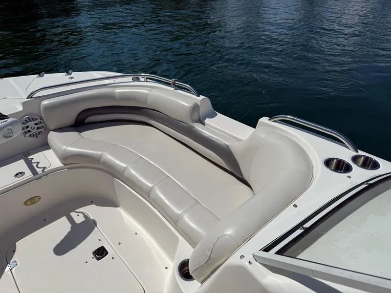 Slide: The Image of 2006 Hurricane SD 237 boat interior with white cushioned seating and cup holders by the water. - 12