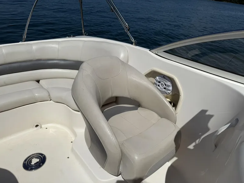 Slide: The Image of 2006 Hurricane SD 237 boat interior with white seating and speaker, on calm water. - 15