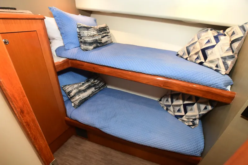 Slide: The Image of Bunk beds with blue bedding in a 2000 Viking Boats 65 C cabin. - 18