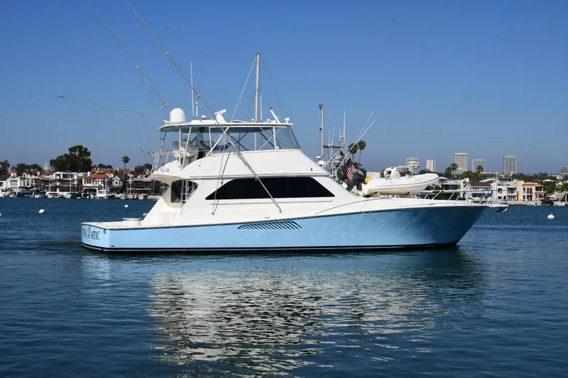 Slide: The Image of 2000 Viking Boats 65 C yacht on calm water, with cityscape background. - 2