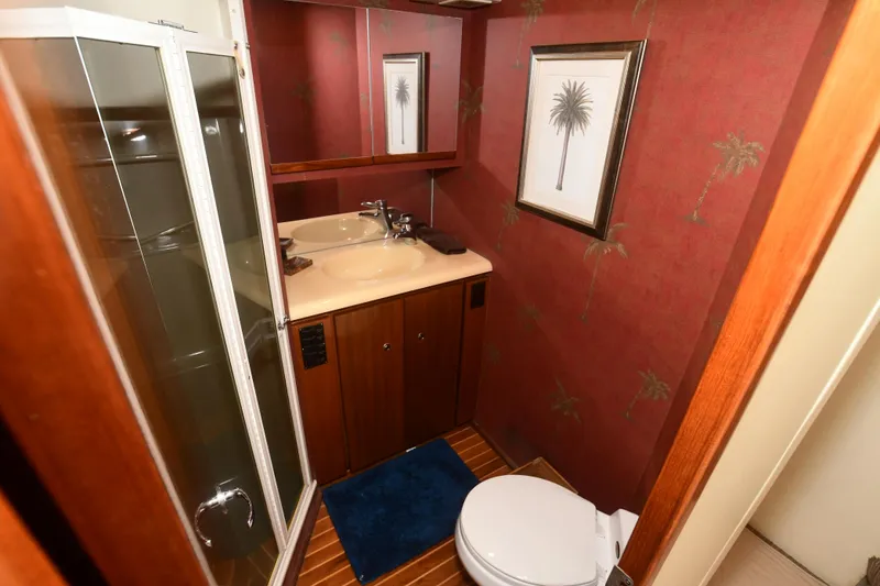 Slide: The Image of Bathroom interior of 2000 Viking Boats 65 C, featuring shower, sink, and palm-themed decor. - 20
