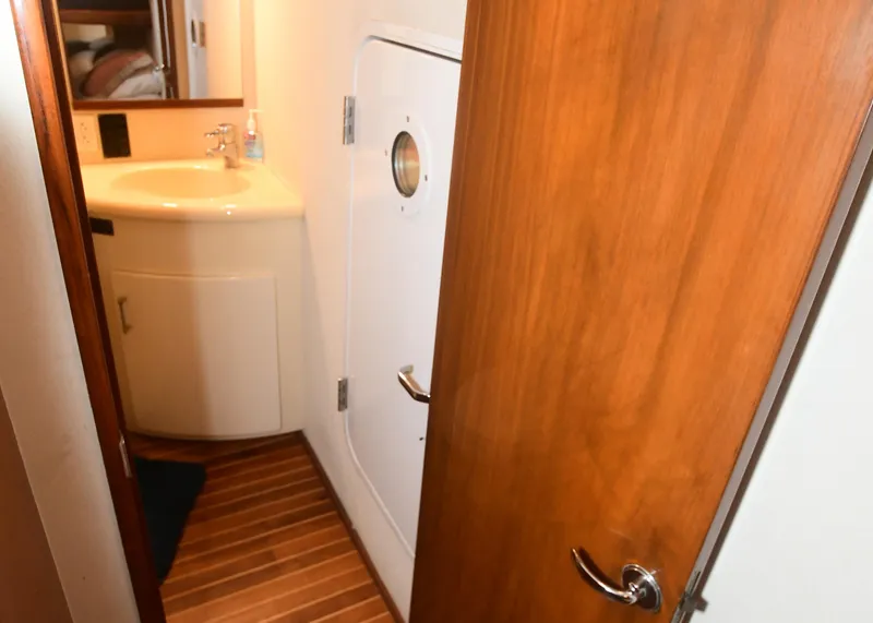 Slide: The Image of Interior of 2000 Viking Boats 65 C, featuring a wooden door and compact bathroom sink. - 26