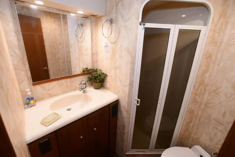 Slide: The Image of Bathroom interior of 2000 Viking Boats 65 C, featuring sink, mirror, and shower. - 3