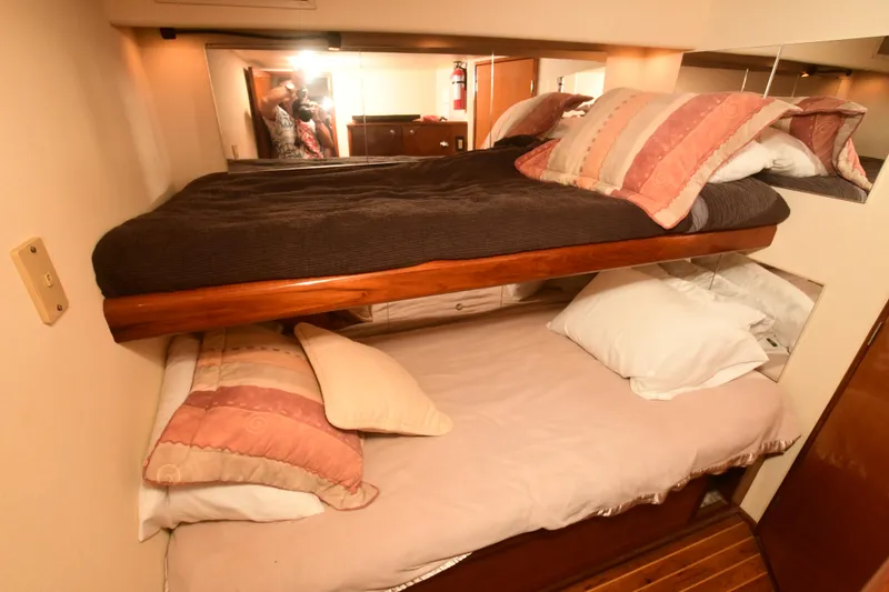 Slide: The Image of Bunk beds in a 2000 Viking Boats 65 C cabin, featuring cozy pillows and wooden accents. - 30