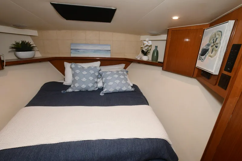 Slide: The Image of Cozy bedroom in 2000 Viking Boats 65 C with nautical decor and wooden cabinetry. - 7