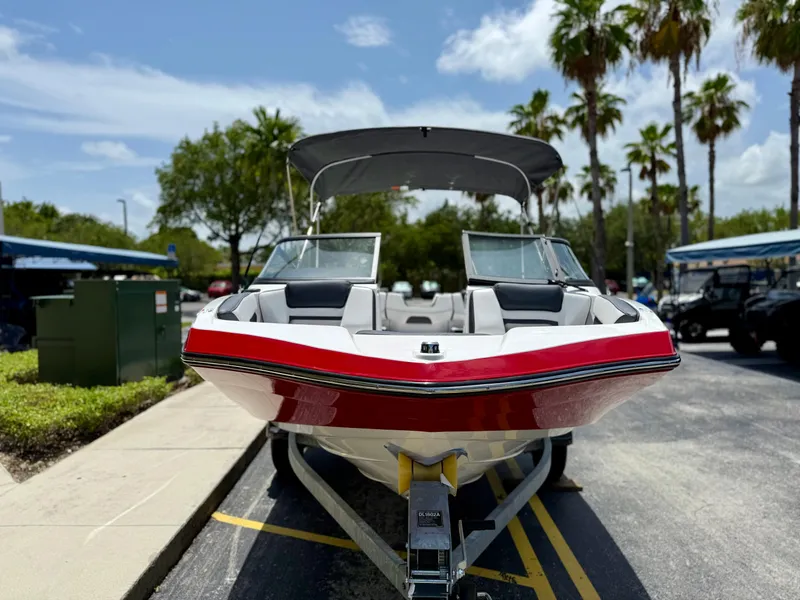 Slide: The Image of 2025 Yamaha Boats SX195 on trailer, parked under sunny skies with palm trees. - 1